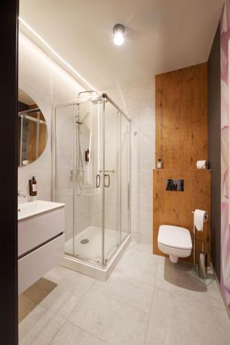 ein Badezimmer mit Dusche, Toilette und Waschbecken in der Unterkunft Fala Park in Wolsztyn