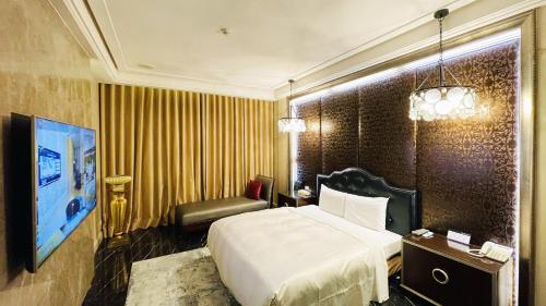 台中市にあるJaneeyre Motelのベッドと椅子のあるホテルの部屋