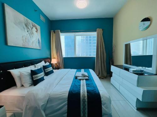 a bedroom with a large bed with blue walls at SKY NEST HOMES PRIVATE 1 BEDROOM APARTMENT DUBAI MARINA in Dubai