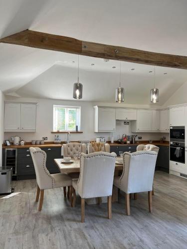 a kitchen and dining room with a table and chairs at Boundary Cottage in Middleton