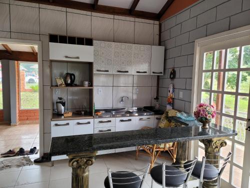 a kitchen with white cabinets and a counter top at Casa Mirante Bixo Do Mato in Muçum