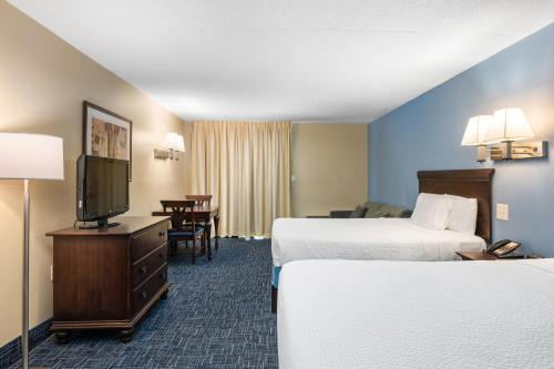 Ένα ή περισσότερα κρεβάτια σε δωμάτιο στο Coastal Palms Inn and Suites