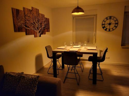 a dining room with a table with chairs and a clock at Ferienwohnung NR1 in Großräschen