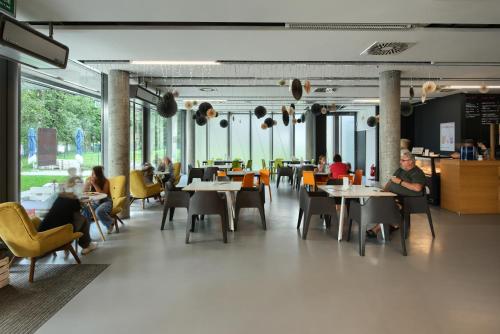 a restaurant with tables and chairs and people sitting at tables at Fala Park in Wolsztyn