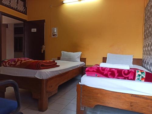 two beds sitting next to each other in a room at Hotel Aane in Itānagar