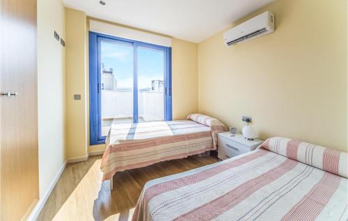 two beds in a room with a window at Amazing Apartment In Torreblanca With 3 Bedrooms in Torreblanca
