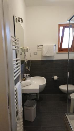 a bathroom with a sink and a toilet and a mirror at Hotel Gasparina in Castelnuovo del Garda