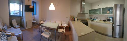 a kitchen with a table and chairs and a refrigerator at Campo da Lúa 4 in Muros