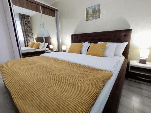 a bedroom with a large bed with a large mirror at Simona Apartament Palas Mall 1 in Iaşi