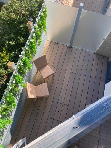 a deck with two benches and a swimming pool at The Bay house Apartments , shanklin in Shanklin