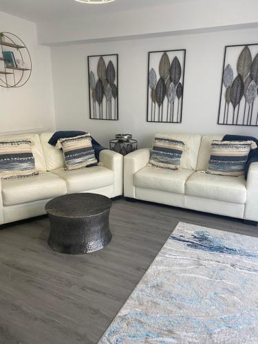 a living room with two white couches and a table at The Bay house Apartments , shanklin in Shanklin