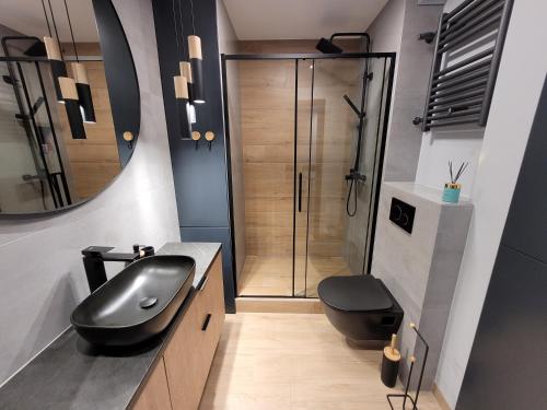 a bathroom with a black sink and a shower at Apartament Stare Miasto Gdańsk z widokiem na Motławę in Gdańsk
