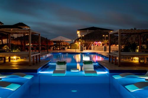 a swimming pool at night with blue lighting at Grand Windsock Bonaire in Kralendijk