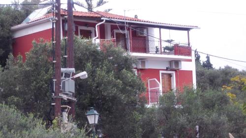 a red and white house on a hill with trees at Belvedere Zakynthos Studios in Vasilikos