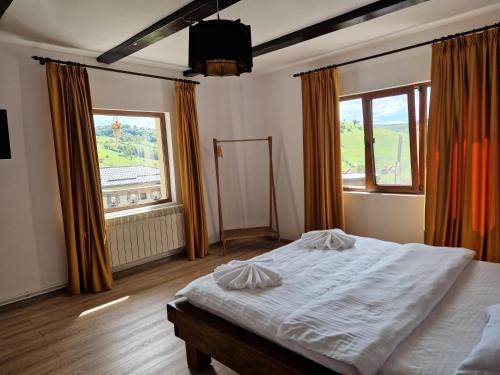 a bedroom with a bed and a large window at Complex Dealu' Frumos in Întorsura Buzăului