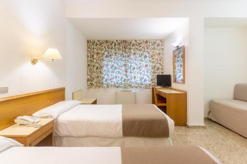 een hotelkamer met 2 bedden en een bank bij Hotel Leuka in Alicante