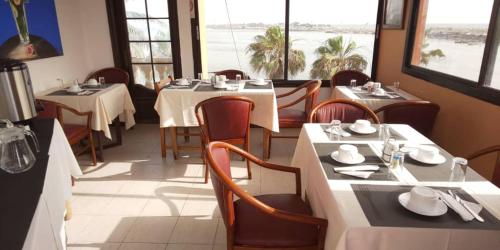 - un restaurant avec des tables et des chaises dans une salle dans l'établissement Hôtel La Palmeraie Saint Louis Sénégal, à Saint-Louis
