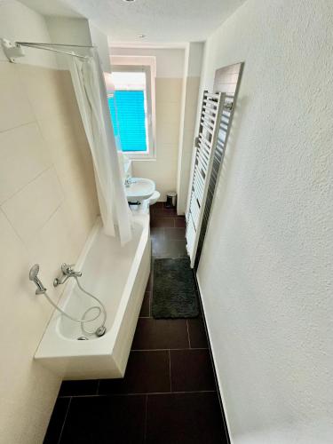 a bathroom with a tub and a sink and a toilet at KMHosting Deluxe 2-Bedroom Apartment Full Kitchen im Zentrum in Chemnitz