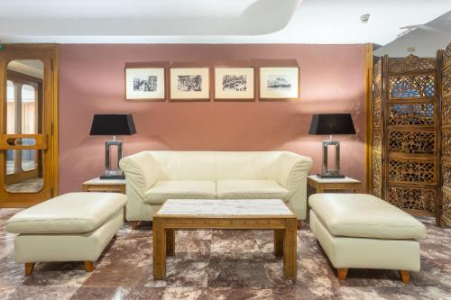 a living room with a couch and a table and chairs at Hotel Leuka in Alicante