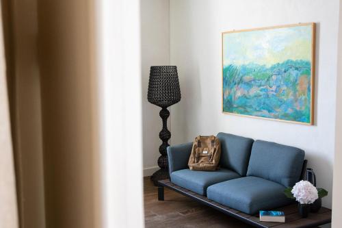 a living room with a blue couch and a lamp at Villa Sizzo Relais B&B in Trento