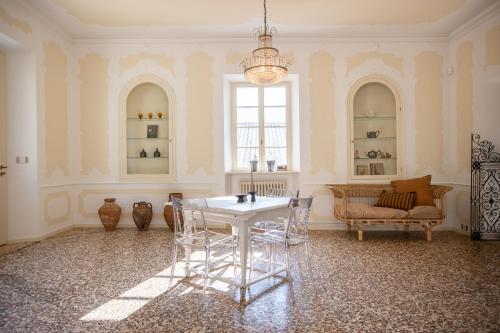 a room with a table and chairs and a chandelier at Villa Sizzo Relais B&B in Trento