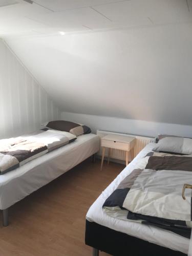 a room with two beds and a table in it at Seaside Top in Thisted