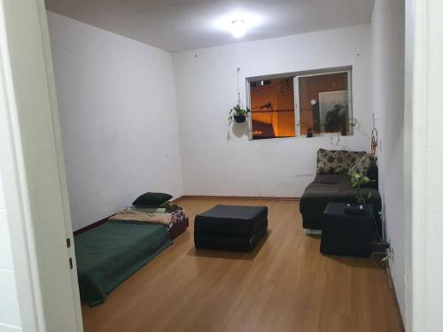 a living room with a bed and a couch at Estudio no centro de campinas 26m² in Campinas