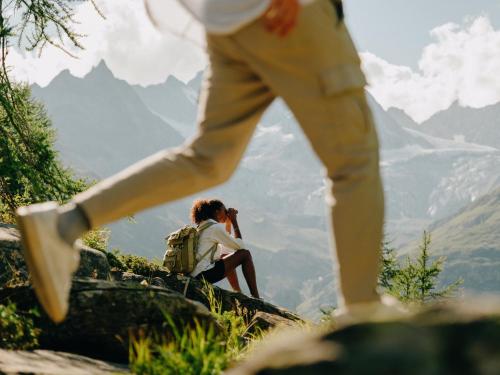 a man standing on top of a mountain taking a picture at BEAUSiTE Zermatt in Zermatt