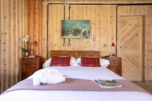 een slaapkamer met een bed met houten wanden en houten vloeren bij QC House - Chalet con Sauna in Santa Caterina Valfurva