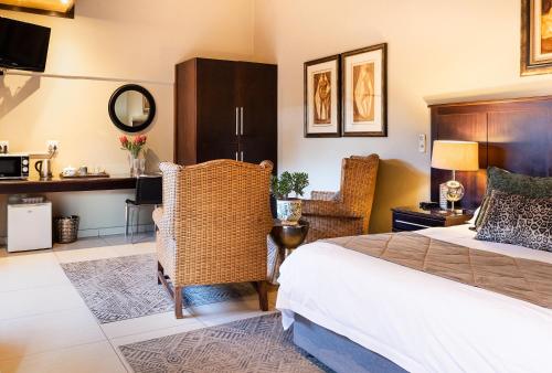 una camera d'albergo con letto e scrivania di Kathu Gamagara Lodge a Kathu