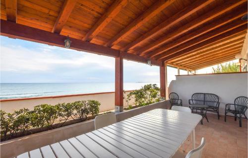 einen Tisch und Stühle auf einem Balkon mit Meerblick in der Unterkunft Beautiful Home In Pozzallo With Wifi in Pozzallo