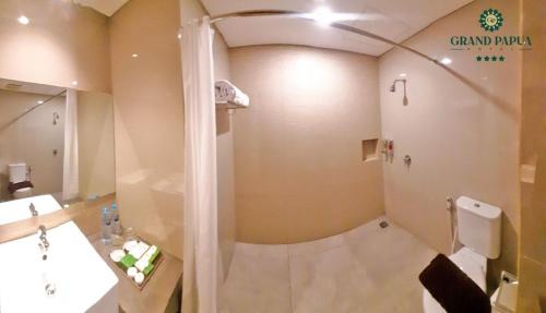 y baño con ducha y aseo. en Grand Papua Hotel Sentani, en Weversdorp