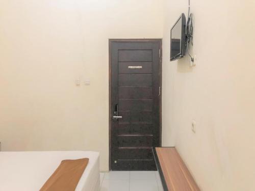 a black door in a room with a tv at Hotel Lido 88 Sorong Mitra RedDoorz in Sorong