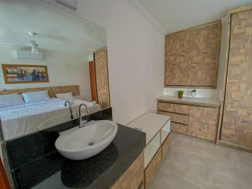 a bathroom with a sink and a bed at Casa Caldeira in Porto Seguro