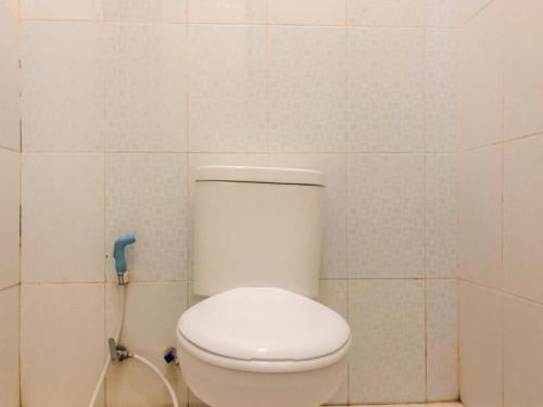 a bathroom with a white toilet and a shower at Hotel Lido 88 Sorong Mitra RedDoorz in Sorong