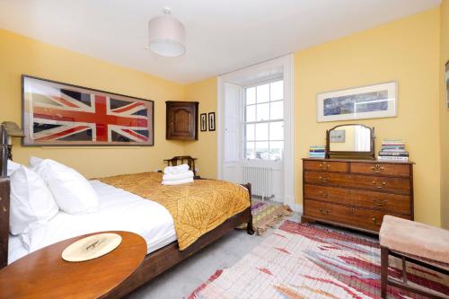 1 dormitorio con cama, mesa y cómoda en JOIVY Inviting flat near city centre, en Edimburgo