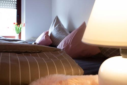 ein Sofa mit einem Haufen Kissen und einer Lampe in der Unterkunft Gästewohnung Mönchengladbach in Mönchengladbach
