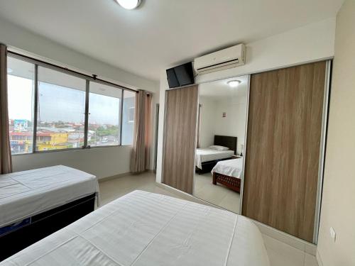 Habitación de hotel con 2 camas y espejo en Edificio Las Palmas 3100 en Santa Cruz de la Sierra