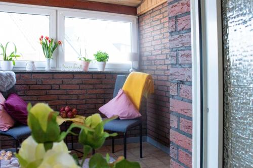 a patio with a brick wall and two chairs and a table at Gästewohnung Mönchengladbach in Mönchengladbach