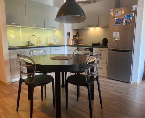 a kitchen with a table and chairs and a refrigerator at Dyrekcyjna Apartment in Wrocław