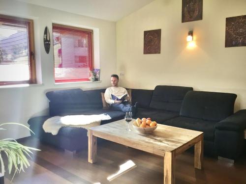a man sitting on a couch in a living room at Astegg, Apart in Finkenberg