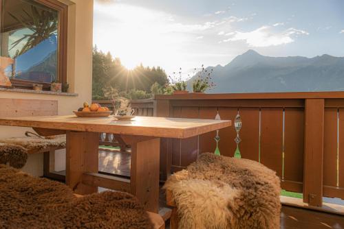 a table on a balcony with a view of a mountain at Astegg, Apart in Finkenberg