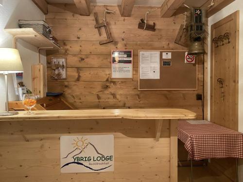 a tasting room with a wooden wall with a table at Ybrig Lodge in Unteriberg