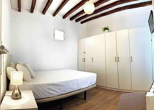 - une chambre avec un lit et des armoires blanches dans l'établissement Céntrico y cómodo apto en Opera Palacio Real Aire Acondicionado WiFi, à Madrid