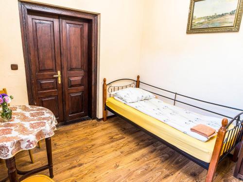 a bedroom with a bed and a table and a door at Bocianówka in Baranów Sandomierski