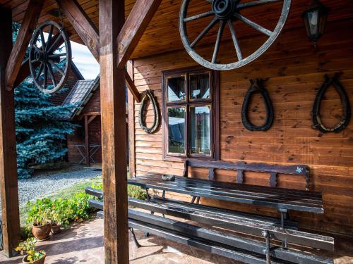a wooden cabin with a bench in front of it at Bocianówka in Baranów Sandomierski