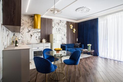 uma cozinha e sala de estar com cadeiras azuis e uma mesa em Luksusowy Apartament Przy Filharmonii em Katowice