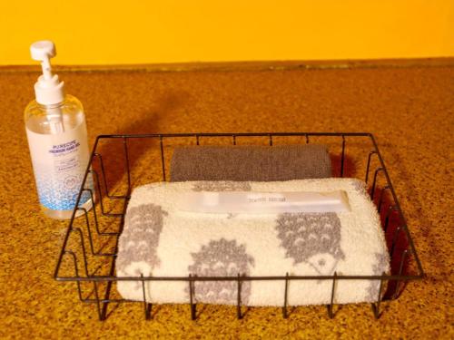 einen Wäschekorb mit einer Flasche Waschmittel daneben in der Unterkunft Guesthouse TOKIWA - Vacation STAY 01074v in Fujinomiya