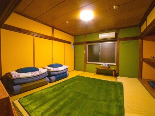 富士宮市にあるGuesthouse TOKIWA - Vacation STAY 01079vのソファ2台と緑の敷物が備わる部屋