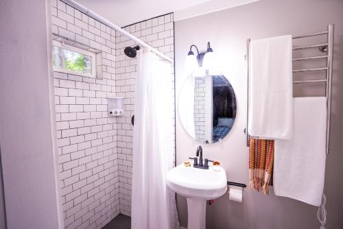 ein weißes Badezimmer mit einem Waschbecken und einem Spiegel in der Unterkunft Foggy Bottom Cabins in Pisgah Forest